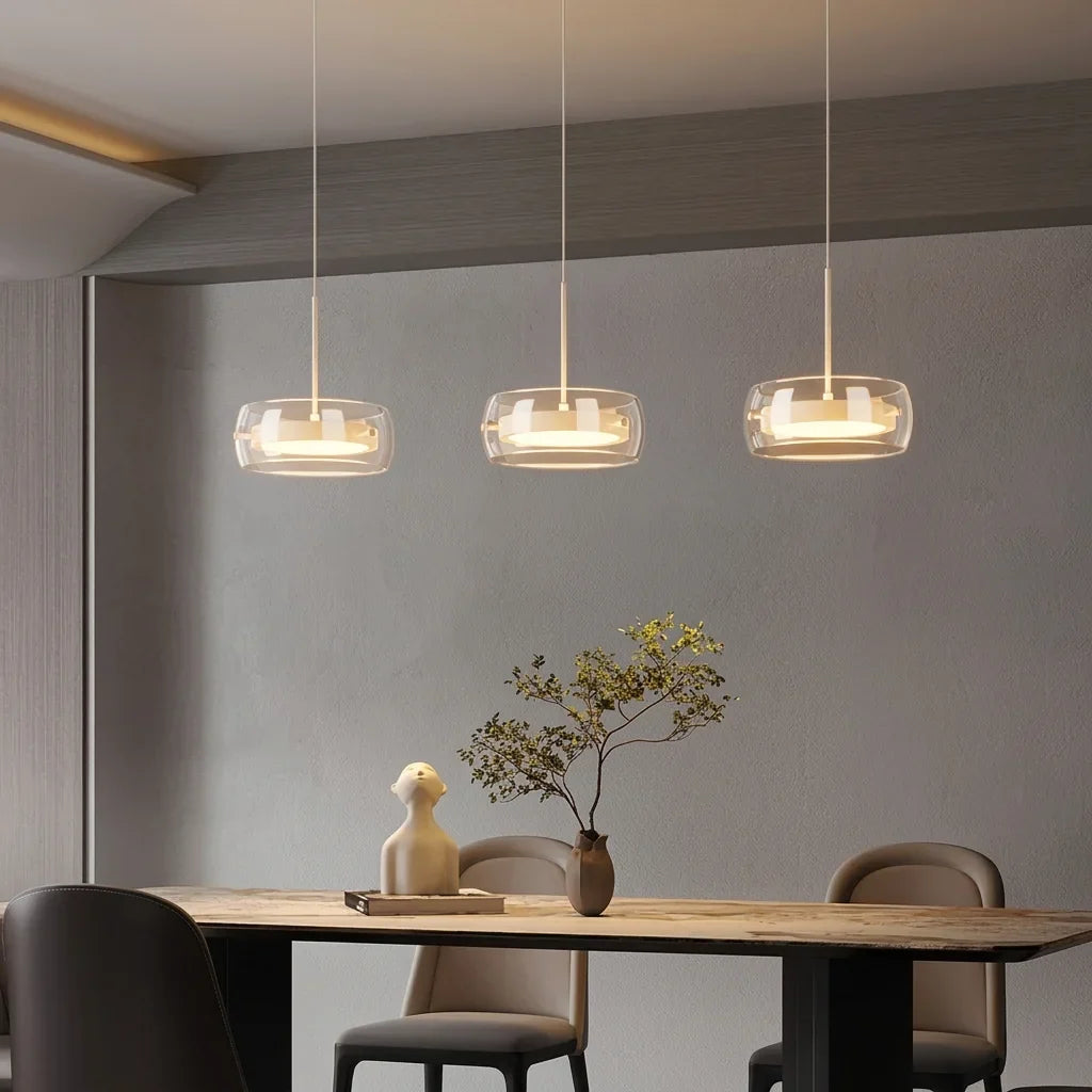Trois suspensions en verre LED au-dessus d’une table