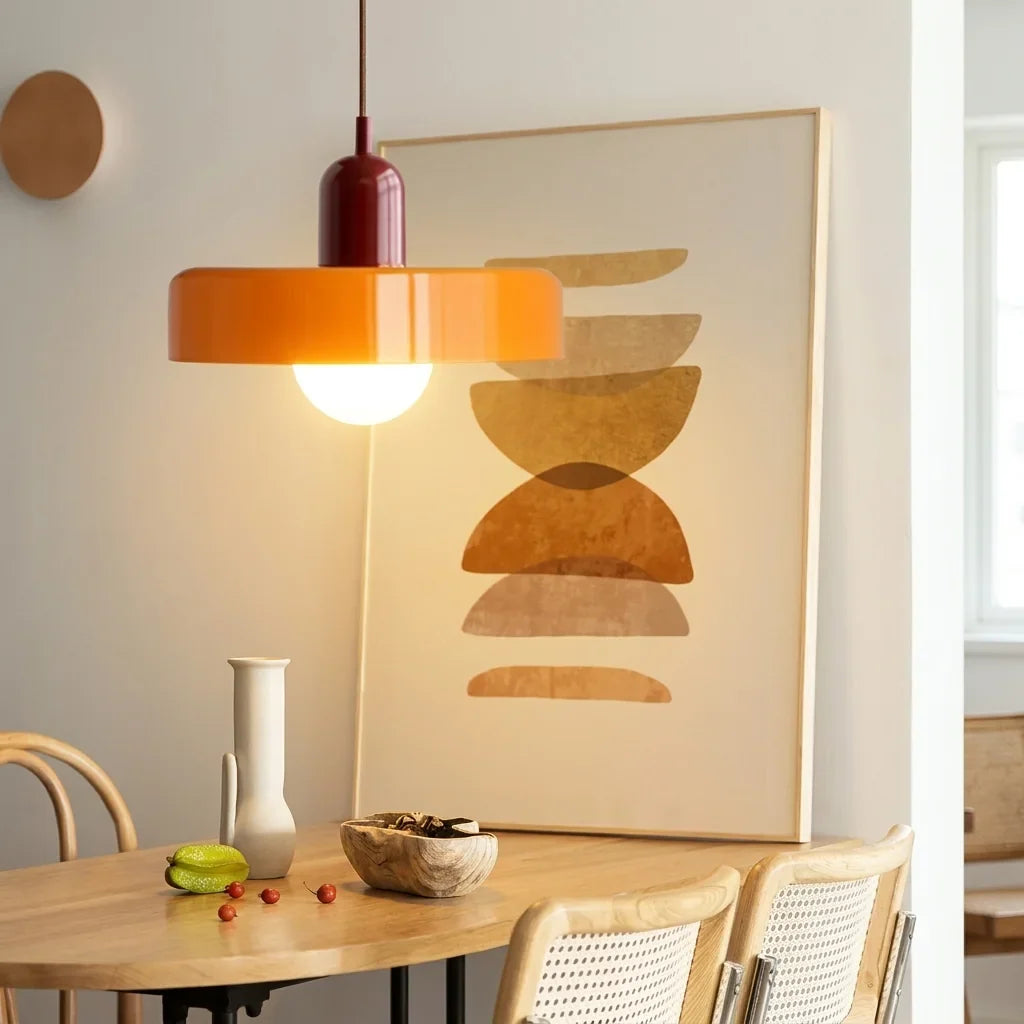 Suspension disque de verre orange au-dessus d’une table en bois