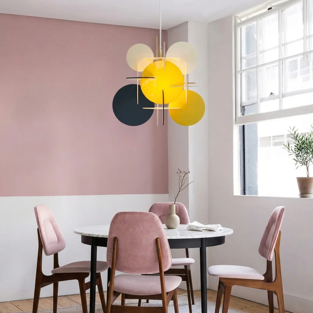 Suspension disques jaune dans une salle à manger aux murs roses