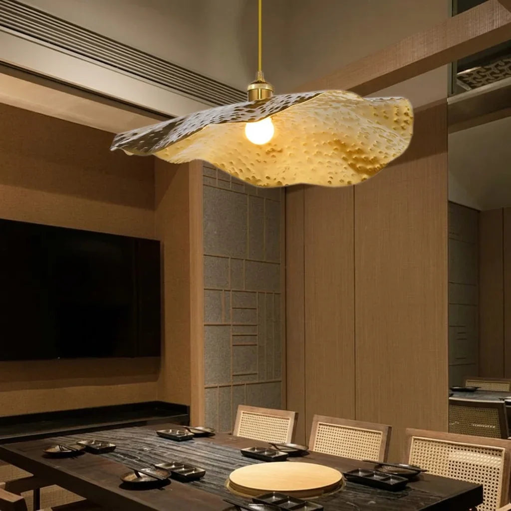 Suspension feuille de lotus au-dessus d’une table en bois sombre