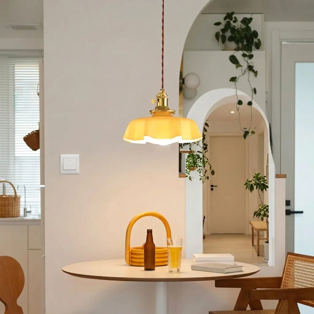 Suspension en verre jaune pâle au-dessus d’une table ronde de cuisine