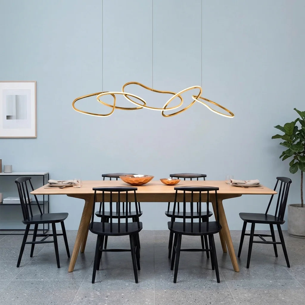 Suspension à anneaux dorée au-dessus d’une table en bois