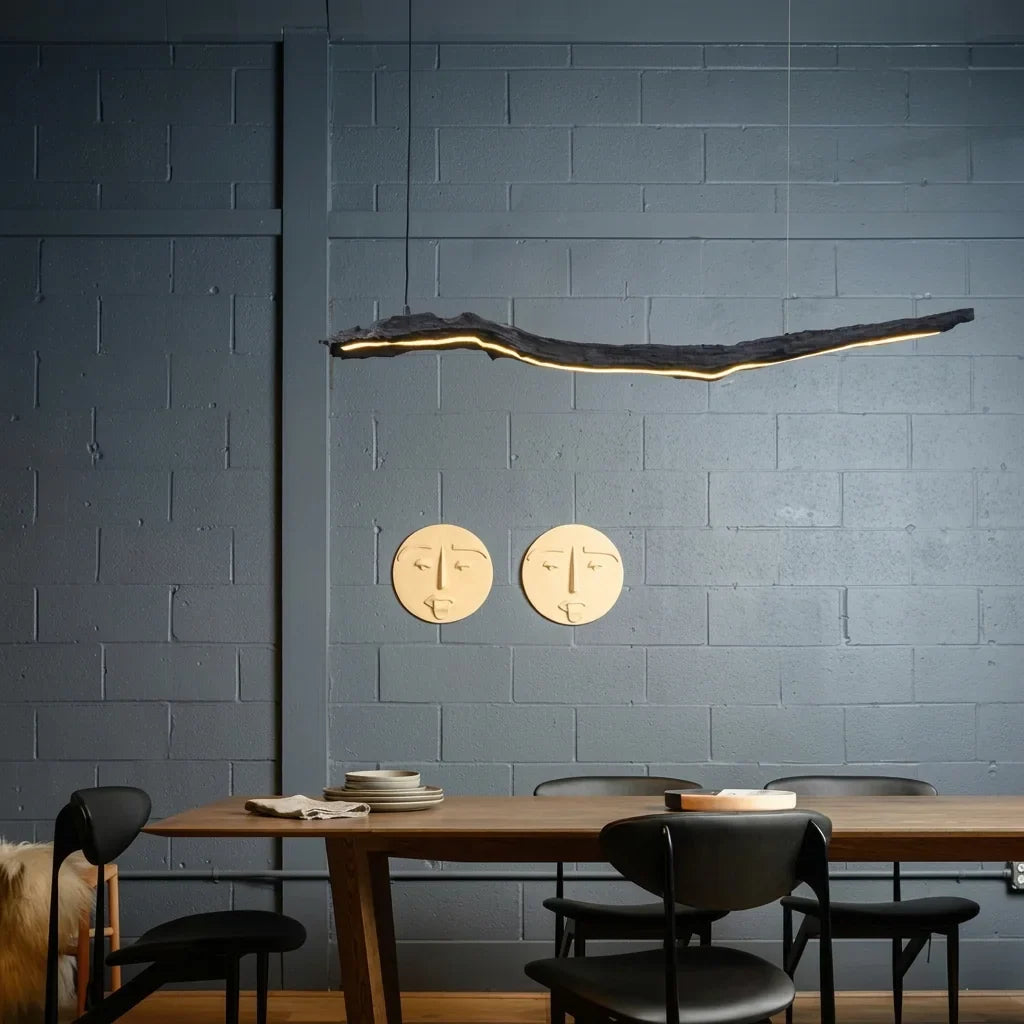 Suspension branche LED au-dessus d’une table près d’un mur en briques peintes