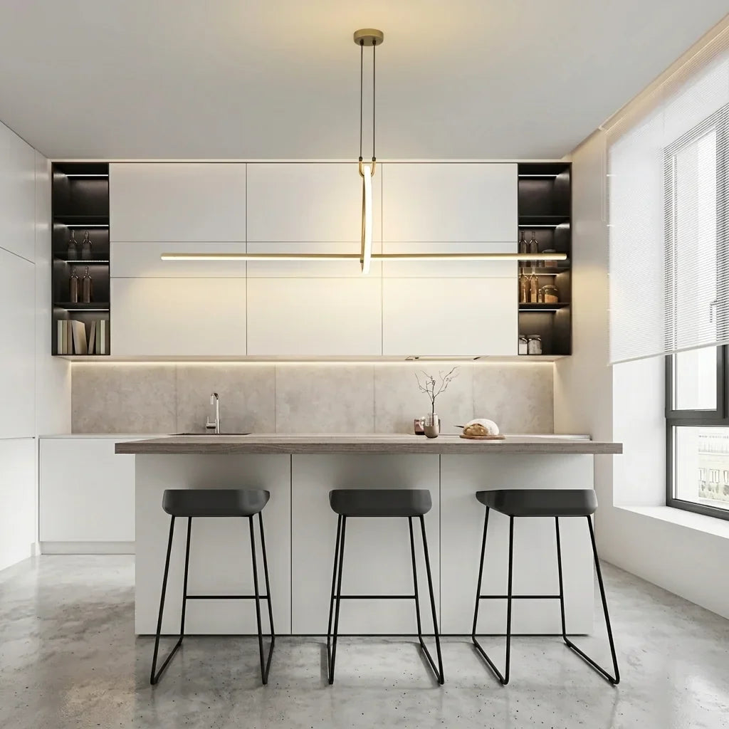 Suspension LED en croix dorée au-dessus d’un îlot de cuisine blanc