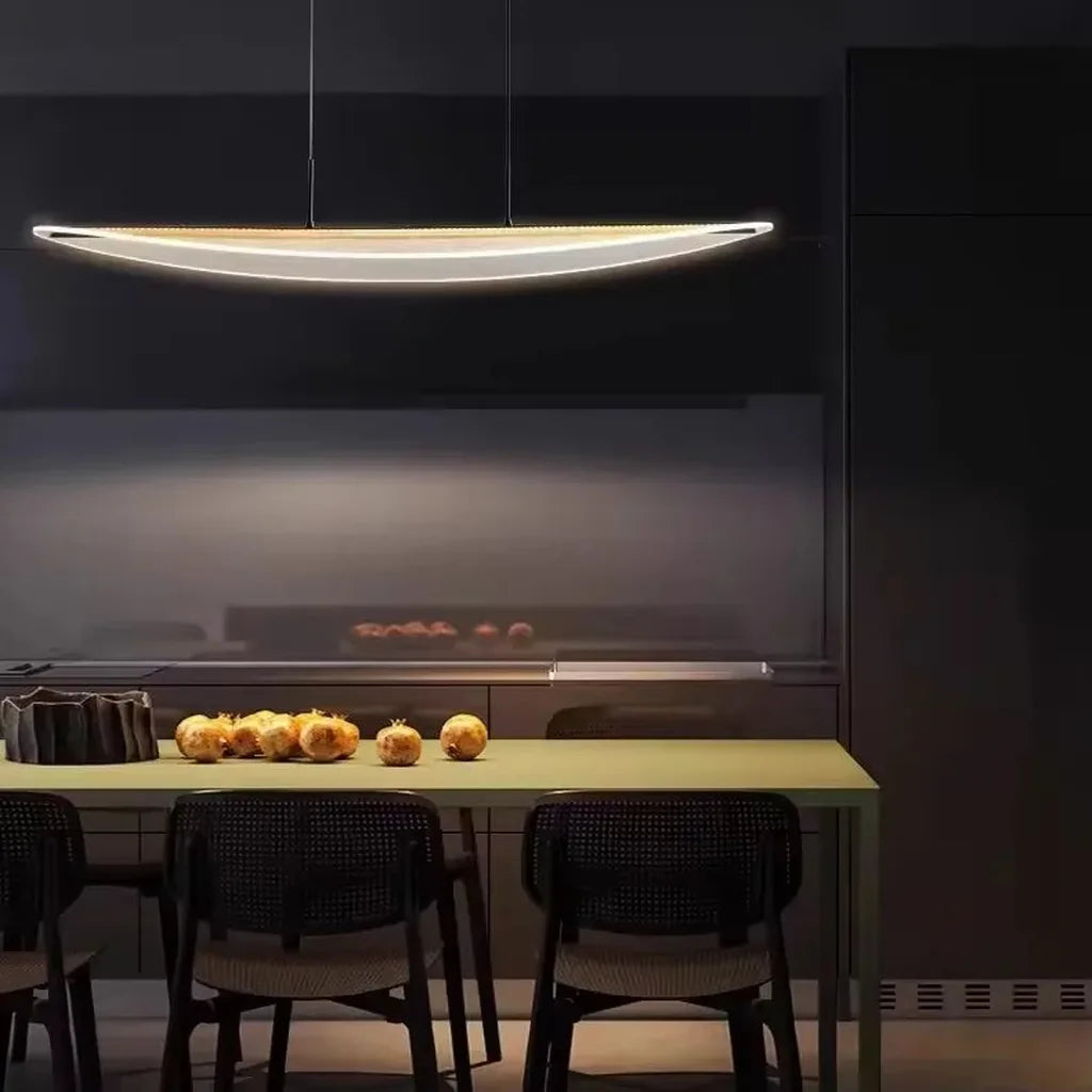 Suspension LED feuille allumée au-dessus d’une table dans une salle à manger sombre