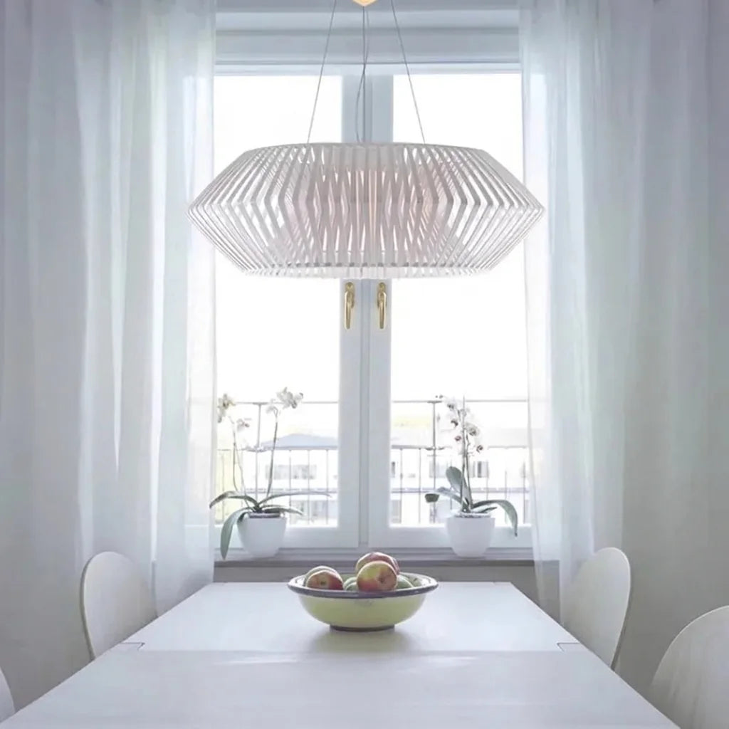 Suspension blanche à lamelles au-dessus d’une table claire