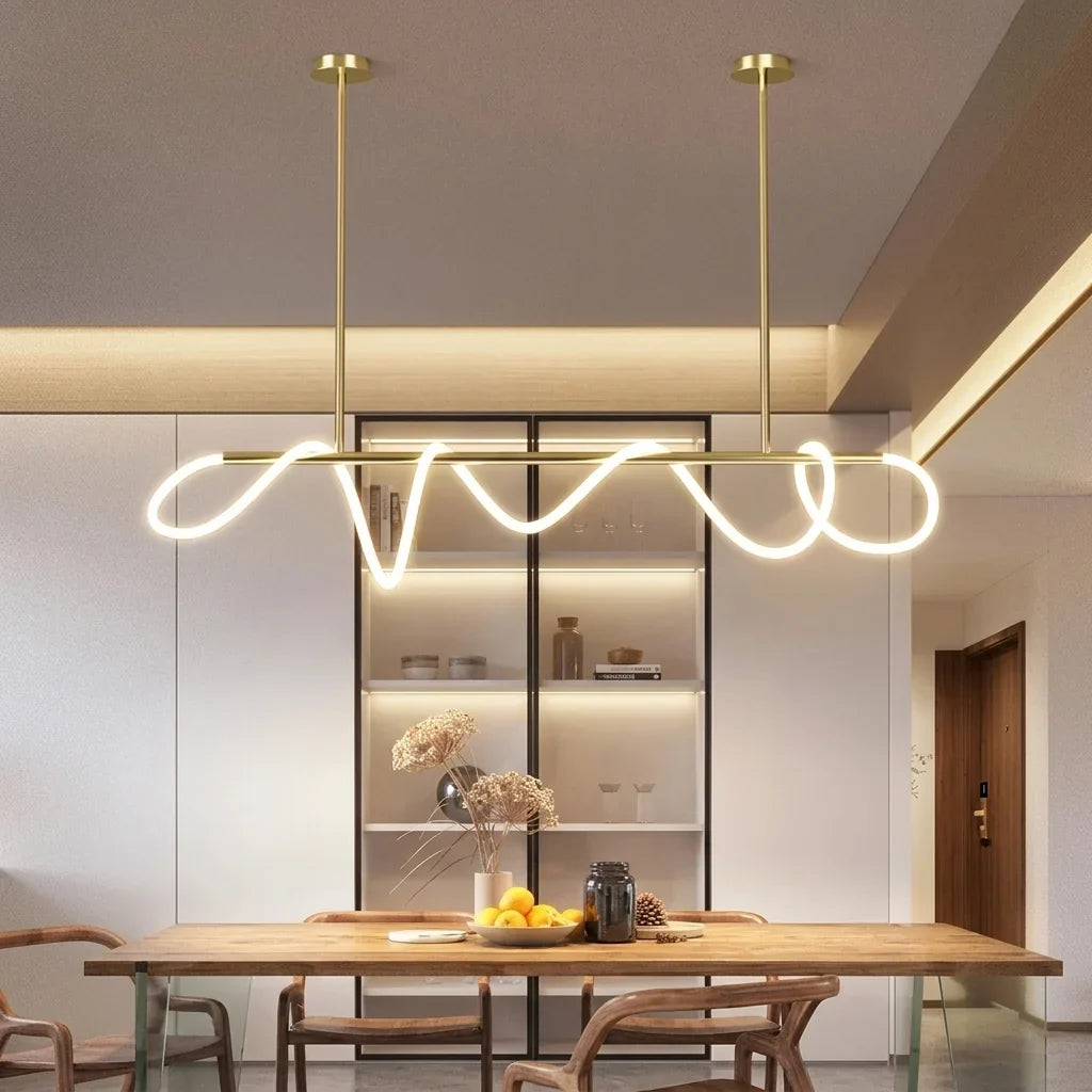 Suspension LED ondulée dorée au-dessus d’une table en bois