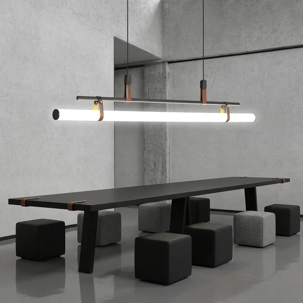 Suspension tube noire au-dessus d’une longue table dans un loft