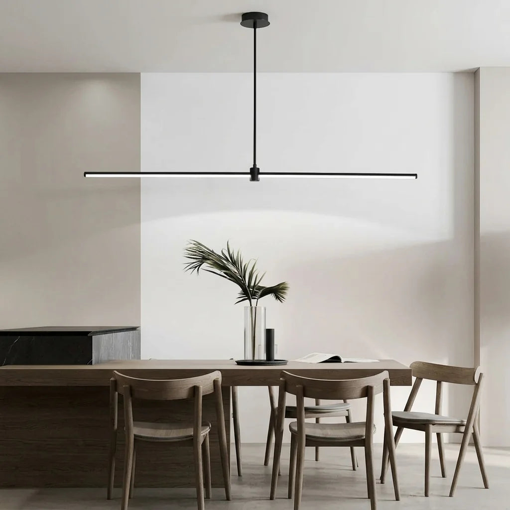 Suspension linéaire noire au-dessus d’une table en bois