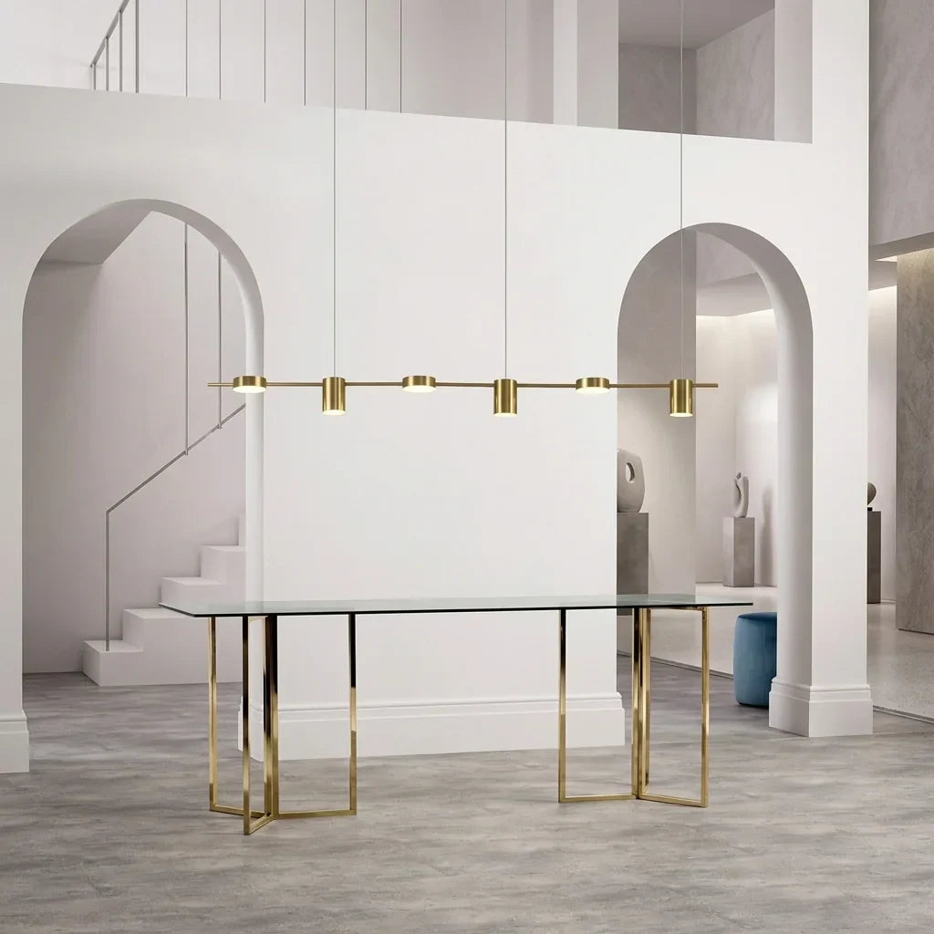 Suspension linéaire dorée au-dessus d’une table en verre
