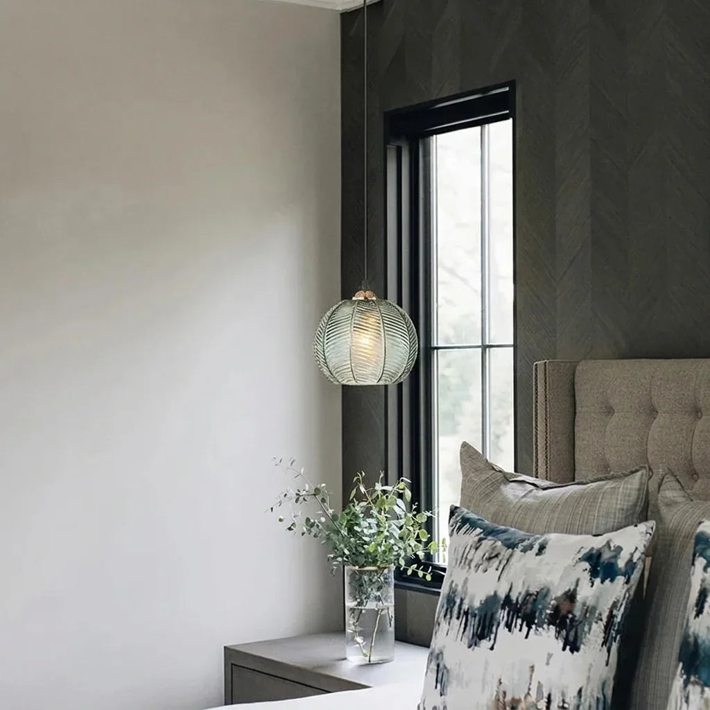 Suspension en verre vert à côté d’un lit