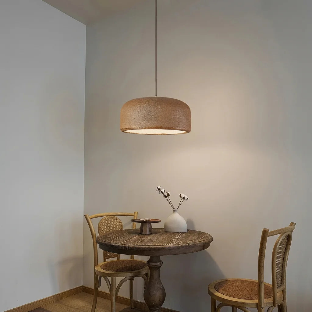Suspension wabi-sabi brune au-dessus d’une table ronde en bois